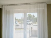 Voilage anti-ondes blanc installé devant une fenêtre double vantail
